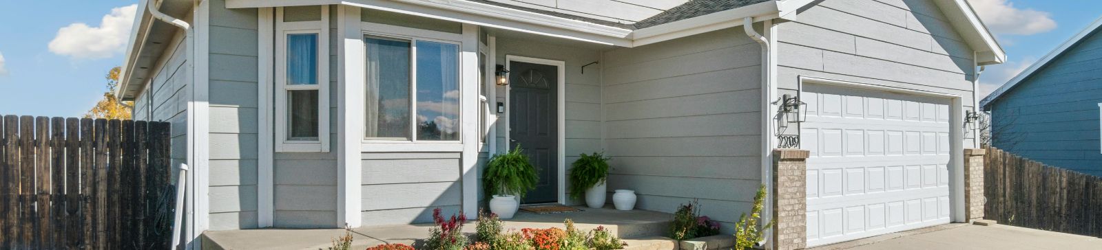 White suburban house with well-maintained lawn and attached garage—ideal for Forest Hills neighborhood.