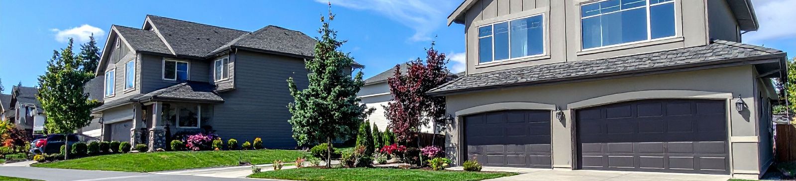 Front view of a contemporary home in Forest Hills, NY, featuring a double garage door and well-kept landscaping—ideal for showcasing local garage door repair services.