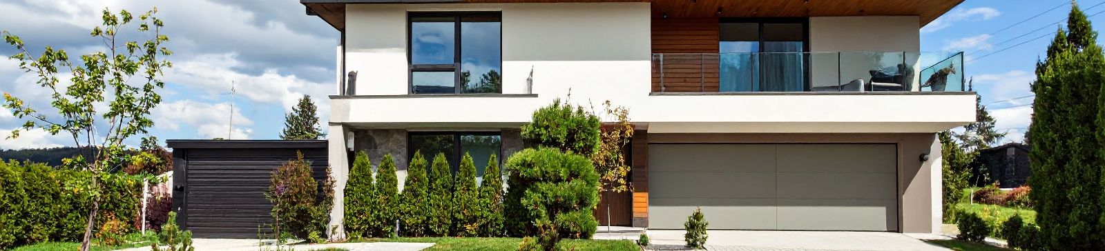 A Forest Hills resident reviewing a blog filled with garage door maintenance, repair, and opener advice on their laptop, with photos of modern doors and smart opener controls.