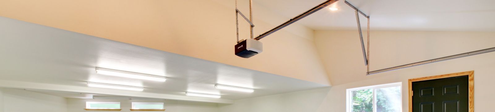 Bright garage interior featuring a newly installed opener system and fresh sectional door in Forest Hills NY