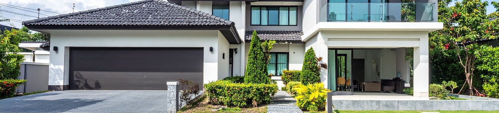 Front view of an attractive home in Forest Hills, NY with a double garage door, stylish landscaping, and a clean driveway—perfect for illustrating quality garage door repair services.