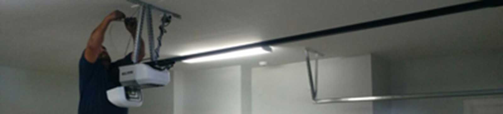 Professional garage door technician mounting an automatic opener in New Hyde Park NY home garage