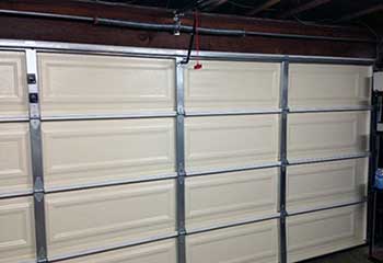 Cream-colored sectional steel garage door after installation in Forest Hills NY garage