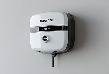 Homeowner comparing garage door opener models and smart features on a laptop in a Forest Hills, NY living room.